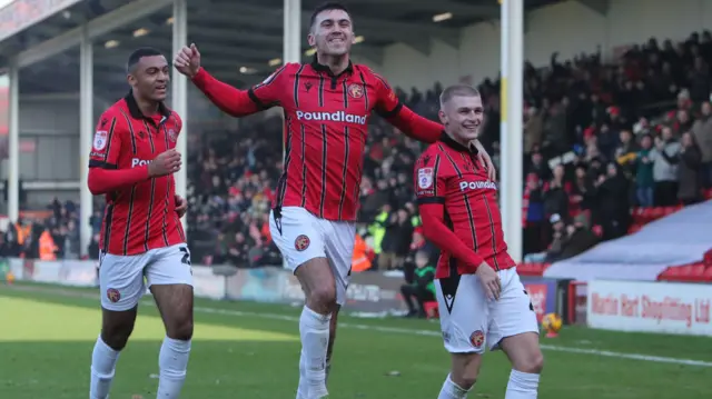 Walsall players celebrate with Ryan Stirk (right) after he scores their second goal against Tranmere