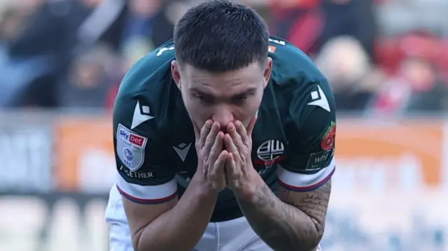 Bolton midfielder Aaron Morley has his head in his hands