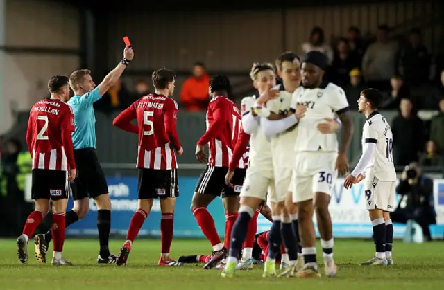 Referee Scott Oldham shows a red card