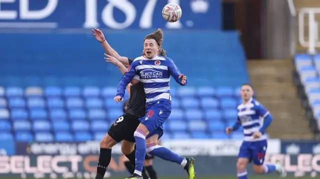 Charlie Savage of Reading jumps for the ball with Jay Rodriguez