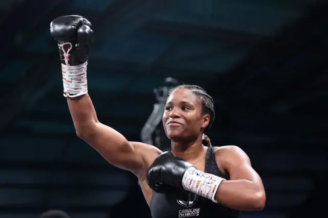 Caroline Dubois celebrates by waving her glove in the air