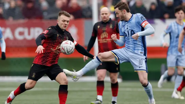 Tamworth's Ben Milnes in action with Tottenham Hotspur's James Maddison