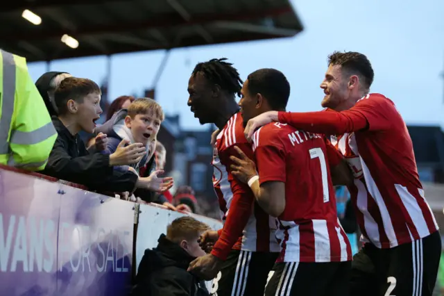 Exeter players celebrate after scoring against Oxford