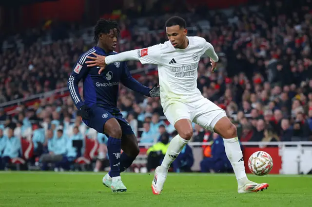 Gabriel Magalhaes of Arsenal holds off a challenge from Kobbie Mainoo