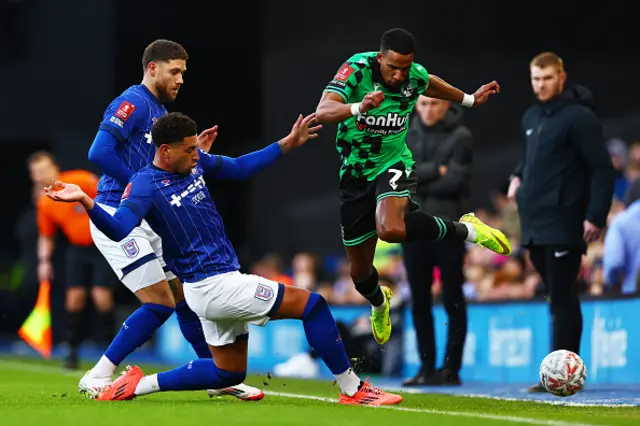 Wes Burns and Ben Godfrey of Ipswich Town battle for possession with Scott Sinclair