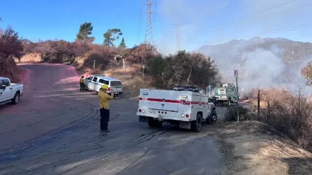 Fire crews parked on a mountain battling flames