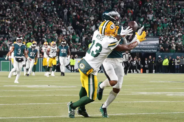 Darius Slay Jr of the Philadelphia Eagles intercepts a pass intended for Dontayvion Wicks of the Green Bay Packers