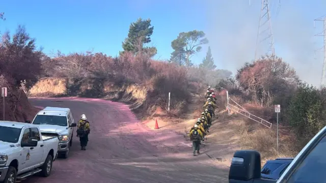 Firefighters walking up a mountain to battle flames