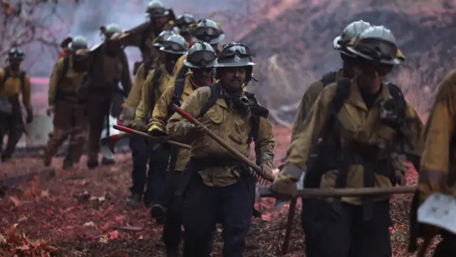 Firefighters hike into the Palisades wildfire in Los Angeles