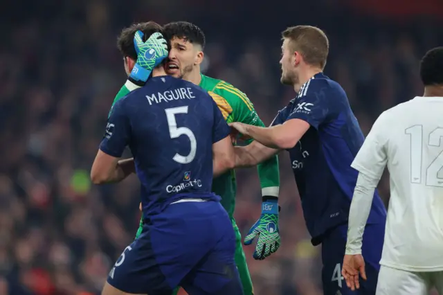 Maguire and Bayindir celebrate after keeping the ball out of the net.