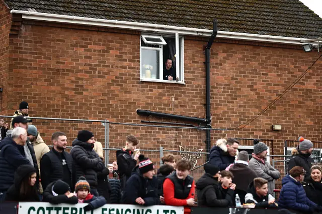 A man views the game from his window