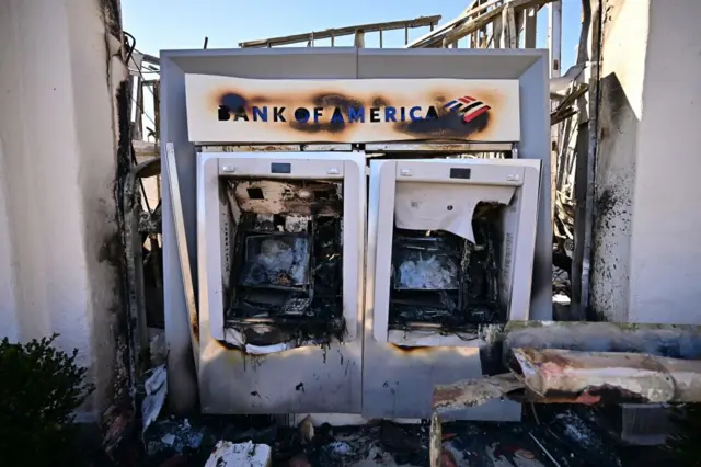 A Bank of America automated teller destroyed by fire and surrounded by rubble