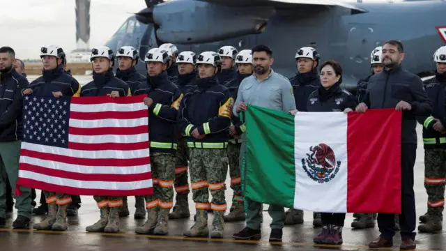 A Mexican military and fire aid team gather before boarding a plane bound for California to help fight wildfires