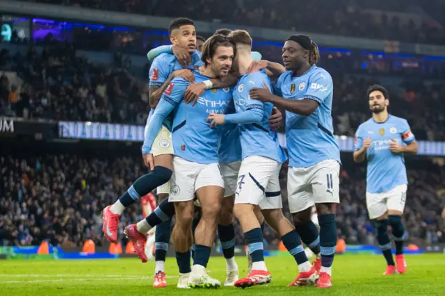 Man City players celebrate after Jack Grealish scores against Salford