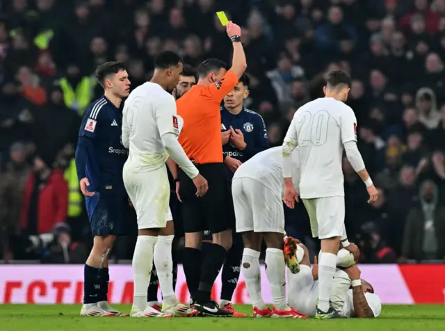 Lisandro Martinez is shown a yellow card