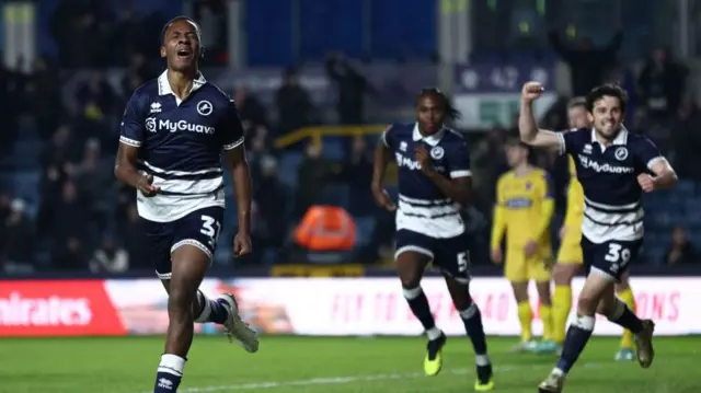 Raees Bangura-Williams has his eyes closed in joy after scoring his first goal for Millwall