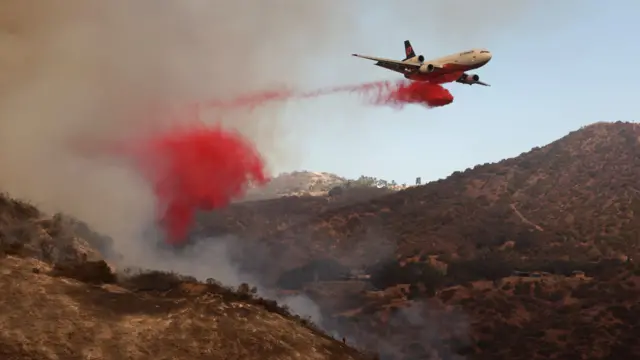 A plane drops fire retardant against the Palisades wildfire in Los Angeles