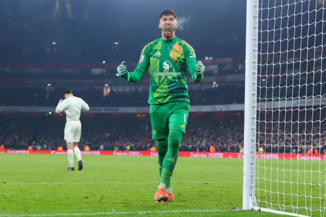 Manchester United goalkeeper Altay Bayindir celebrates after saving a Kai Havertz penalty