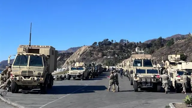 Military hummers line up in a parking lot