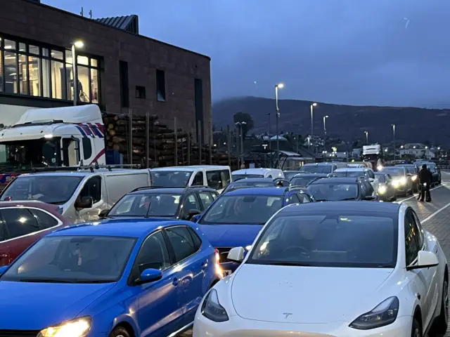 Three queues of cars, side by side, waiting at the port to board