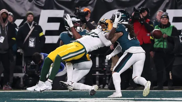 Green Bay Packers wide receiver Romeo Doubs is pulled down by two Philadelphia Eagles defensive players