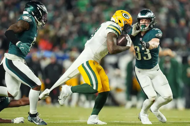 Josh Jacobs has his shirt pulled by a defensive player while making a run for the Green Bay Packers against the Philadelphia Eagles