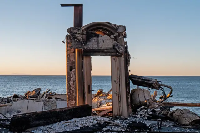 The entrance to a home destroyed by the Palisades wildfire is seen on January 13, 2025 in Malibu, California. Multiple wildfires fueled by intense Santa Ana Winds are burning across Los Angeles County