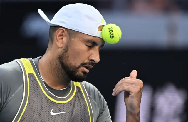 Nick Kyrgios throws a tennis ball at his head