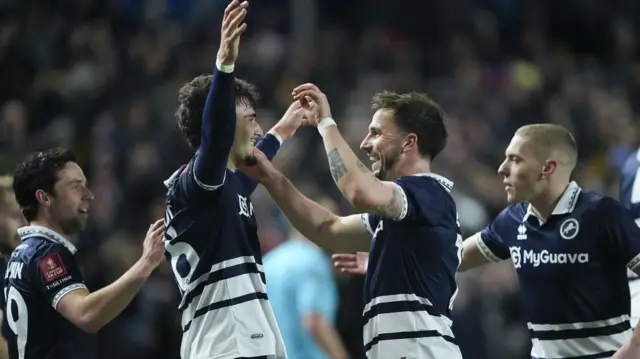 Mihailo Ivanovic receives the congratulations of Millwall team-mate Joe Bryan after opening the scoring against Dagenham & Redbridge