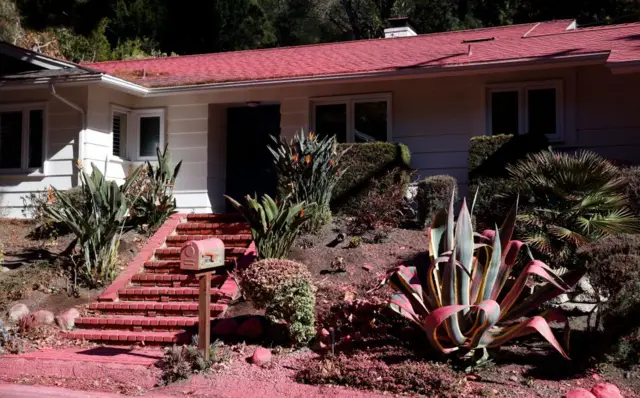 A house is covered in fire retardant in the Pacific Palisades neighborhood in Los Angeles, California, USA, 12 January 2025