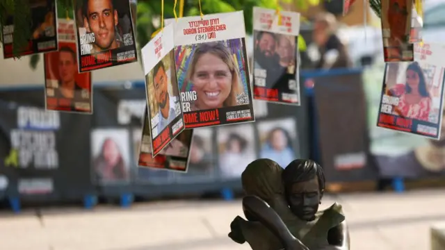 A statue of a mother embracing a child is seen under a tree with the photos of the hostages kidnapped during the deadly October 7, 2023 attack by Hamas and who are still held in captivity, amid the ongoing conflict in Gaza between Israel and Hamas, at the so-called "Hostages Square" in Tel Aviv, Israel, January 1