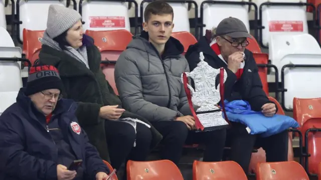 Leyton Orient fans with a tin foil FA Cup inside Brisbane Road