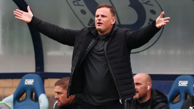 Leyton Orient boss Richie Wellens with his arms outstretched