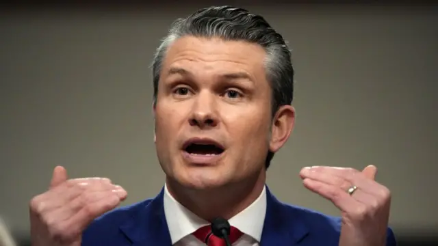 Hegseth gestures as he speaks