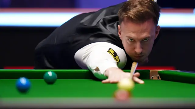 Judd Trump plays a shot