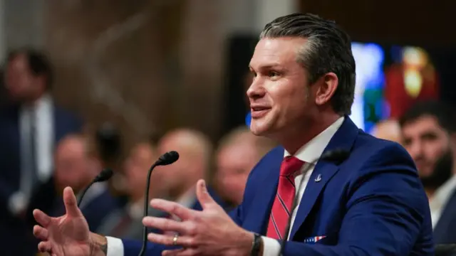 Pete Hegseth gestures with both hands as he speaks