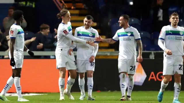 Wigan players celebrate with goalscorer Theo Aasgard