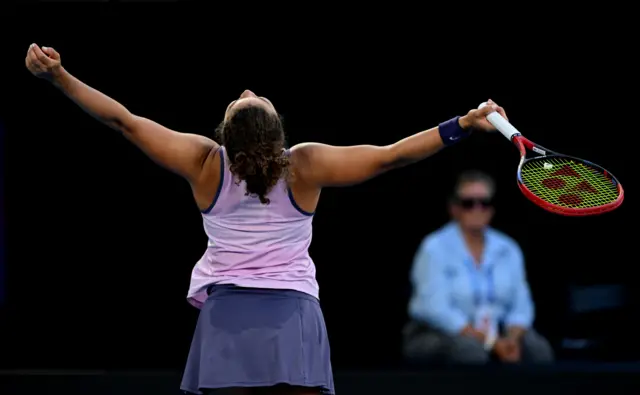 Jasmine Paolini looks to the sky with her arms outstretched