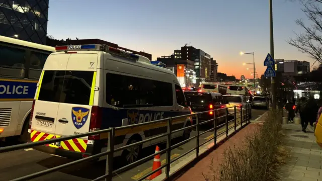 Police vans on a road with heavy traffic