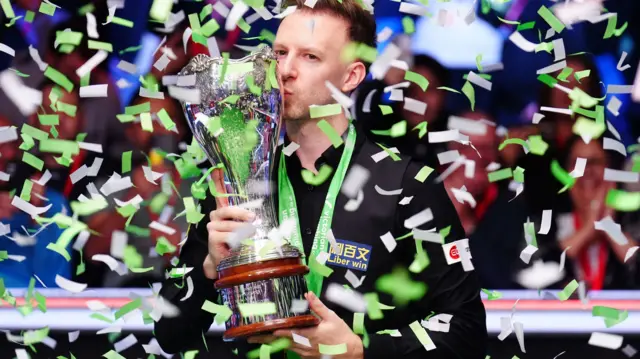 Judd Trump kisses the UK Championship trophy