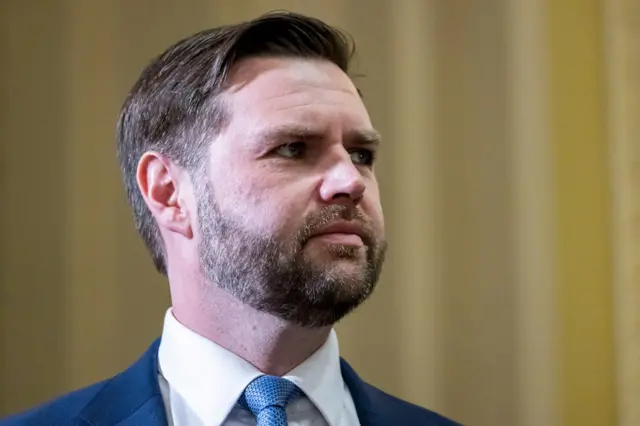 Senator JD Vance wearing a navy suit and light blue tie