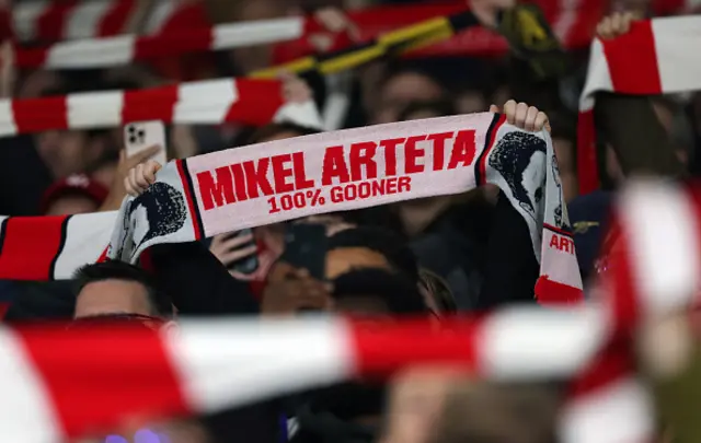 : A fan holds up a scarf saying Mikel Arteta