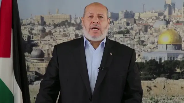 Khalil al-Hayya is pictured giving a speech in Doha, Qatar, with a view of buildings behind him