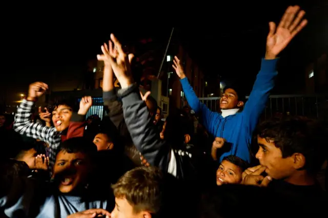 Palestinians react as they wait for news of a ceasefire deal with Israel