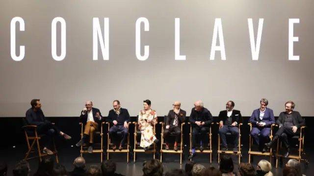 Actors sit on chairs at a Conclave Q&A