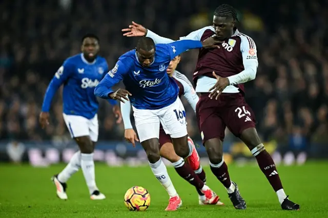 Abdoulaye Doucoure (L) fights for the ball with Amadou Onana