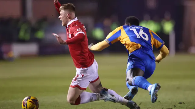 ndy Cannon of Wrexham is challenged by Aaron Pierre of Shrewsbury Town