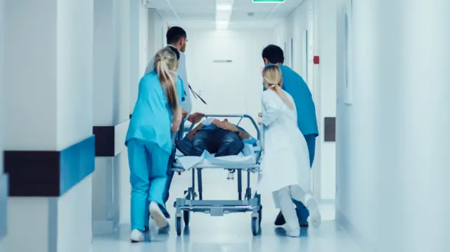 medical staff push a patient on a trolley