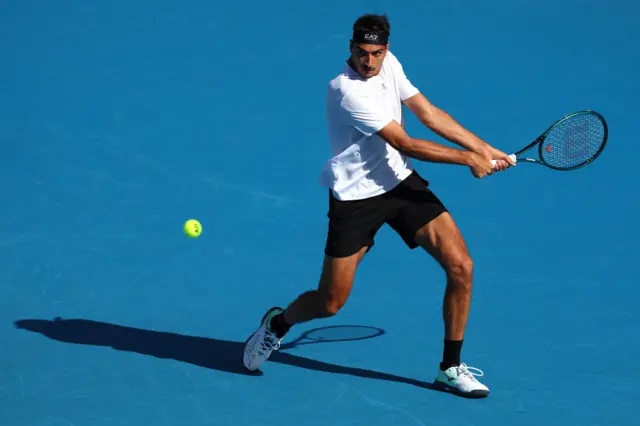 Lorenzo Sonego of Italy plays a backhand against Joao Fonseca