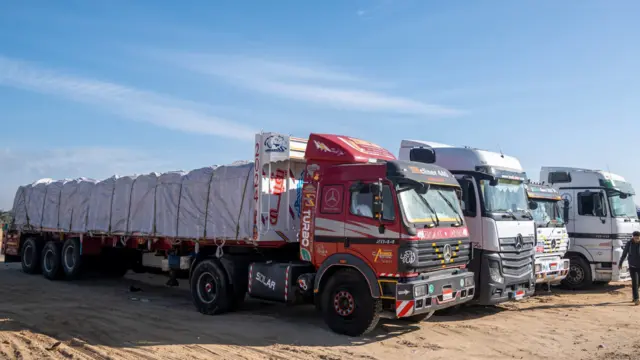 Three trucks loaded with aid waiting at a border between Egypt and Gaza